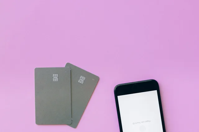 Flat lay of credit cards and smartphone on pink surface, symbolizing digital payment solutions. How to prepare a loyalty marketing tool implementation before launch